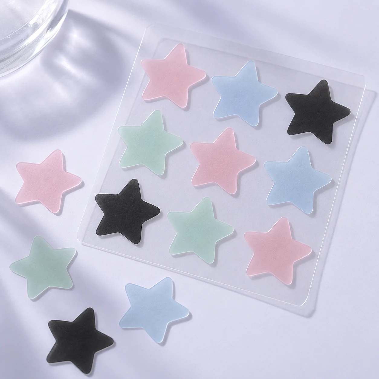 Preview of pink, blue, black and mint star patches on a release sheet